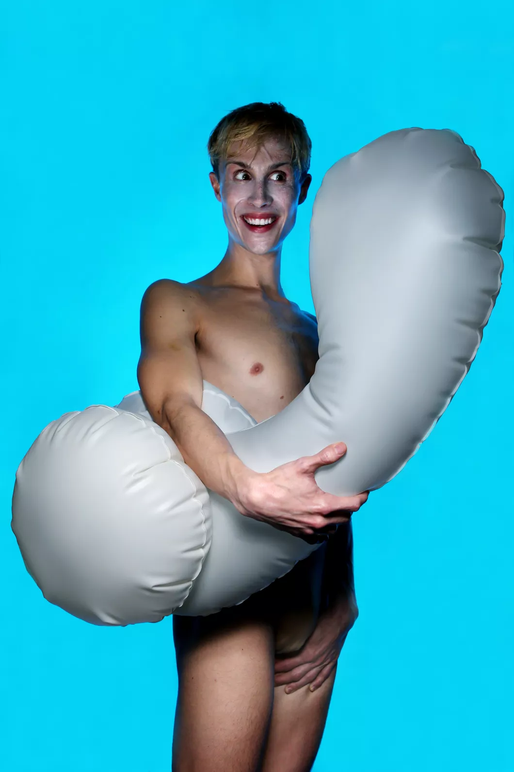 Photo sur fond bleu de Matthieu Barbin avec un pénis glonflable