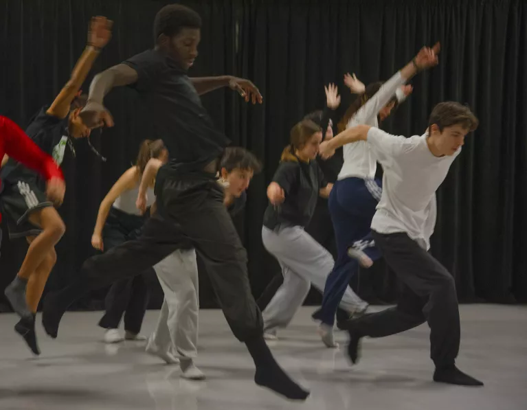 Une dizaine de danseur sautant vers l'avant dans un effet flou