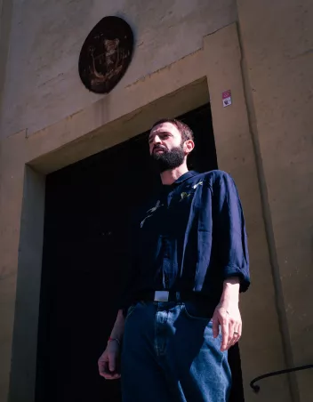 Photo of choreographer Alessandro Sciarroni in front of a door