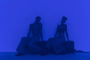 Photo from Jimmy Robert’s show “Joie noire” – two dancers against a blue backdrop
