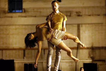 Photo d'un spectacle avec un danseur qui porte une danseuse