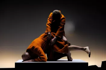 Two dancers wearing orange coats