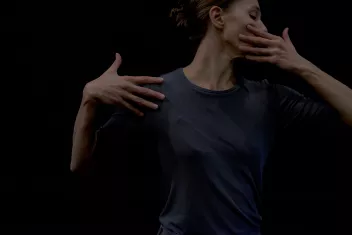 A side-profile photo of Anna Massoni, with one hand on her face