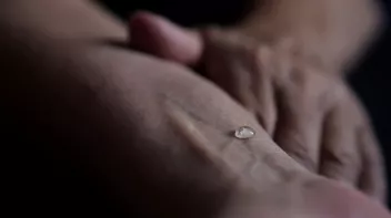 photo zoomée d'un avant-bras avec une goutte d'eau