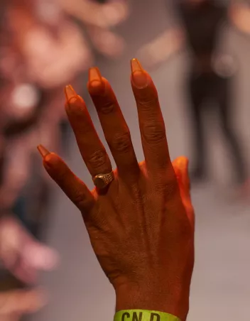 Photo of a hand wearing a yellow CN D bracelet