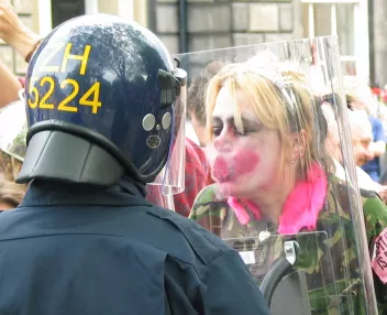 Photo of a protest showing a protester kissing a police officer’s arm