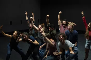 A group of dancers shouting with their arms raised