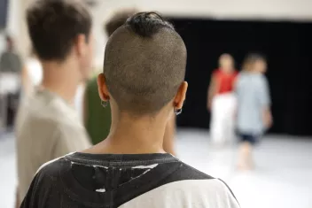 photo of a person seen from behind, with a shaved head 