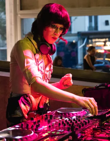 Photo of a DJ behind her turntables