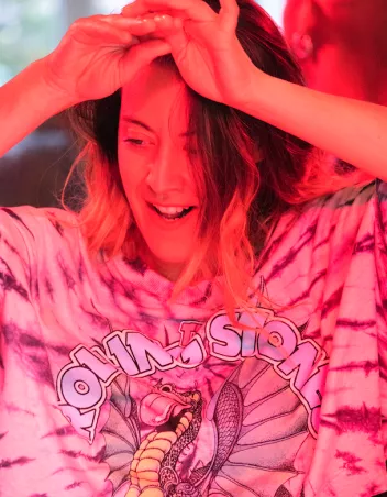 Photo of a woman with her hands on her forehead, wearing a Rolling Stones T-shirt
