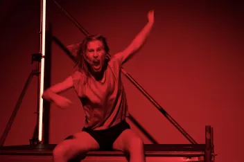 Photo du spectacle "The Dancing Public" de Mette Ingvartsen, assise sur une stucture en train de crier