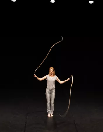Interprète du spectacle "Fléau" avec un fouet dans chaque main