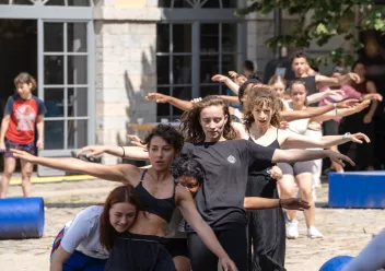 photo de danseurs en extérieur, alignés, les bras à l'horizontale