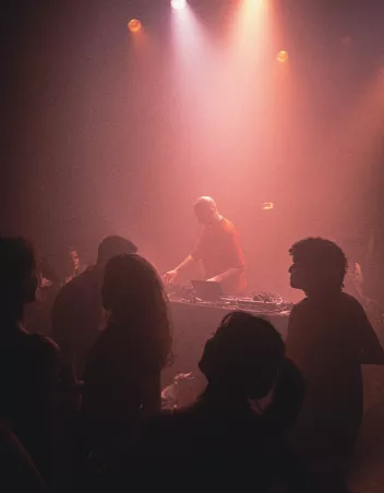 Photo of a party with a DJ mixing