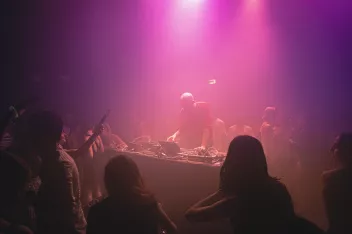 Photo of a party with a DJ mixing