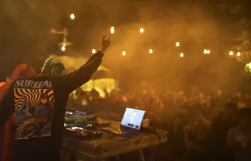 A photo taken from behind the DJ at a party