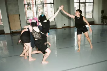Cours de danse avec des danseurs habillés et noir et certains avec un masque