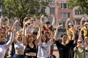 photo of dancers with their arms raised in a ballet pose