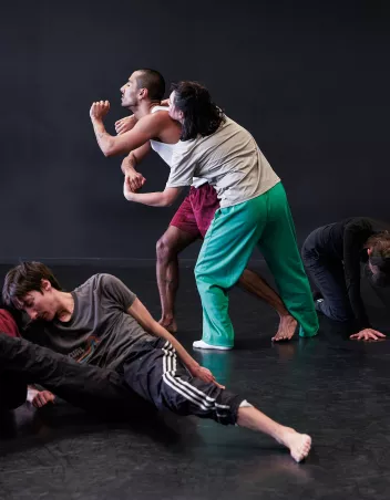 Photo d'un atelier de danse avec deux danseurs debout et un danseur au sol