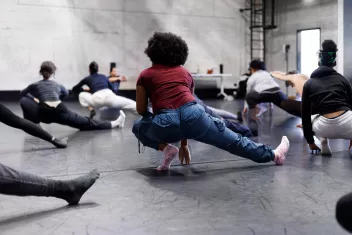 photo of dancers seen from behind as they stretch