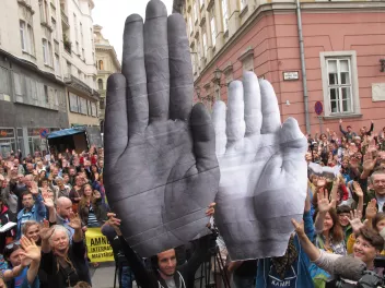 Photo of a demonstration showing protesters holding up pictures of hands