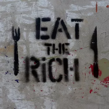 Graffiti featuring cutlery surrounding the phrase ‘Eat the rich’