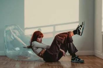 Photo de la chanson Li$on assise par terre devant un fauteuil gonflable transparent