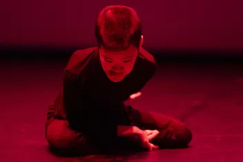 Photo du performer No Anger par terre éclairé par une lumière rouge