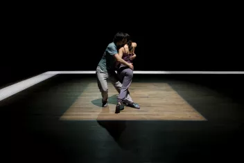 Photo de 2 danseurs de tango au milieu d'un carré de lumière