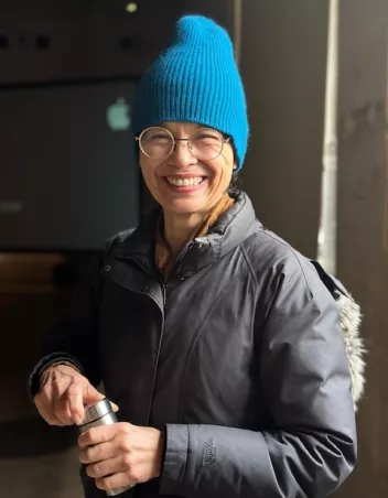 Portrait photo d'Emmanuelle Huynh avec un bonnet bleu sur la tête