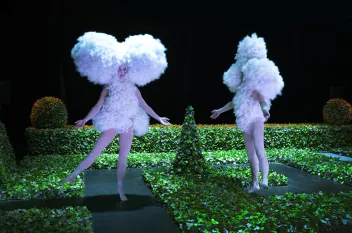 Photo d'un spectacle avec deux danseurs recouverts d'un costume en coton blanc dans un jardin à la française