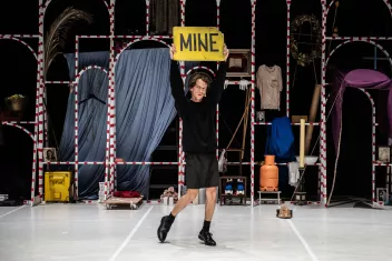 Photo of Matija Ferlin holding a yellow sign with the word ‘Mine’ written on it