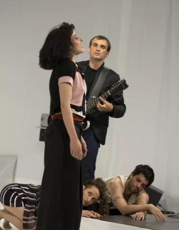 photo d'une chanteuse au premier plan, un guitariste au second plan et deux personnes au sol qui regardent la chanteuse