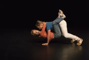 photo d'un spectacle ave deux danseurs au sol avec un masque sur le visage